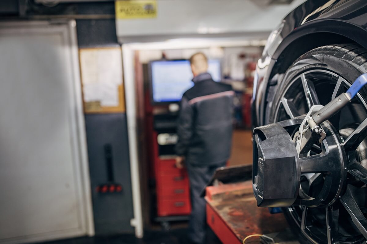 mechanic looking at wheel alignment
